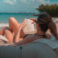 Woman reading a book on a beach with ocean view Fenix Beach