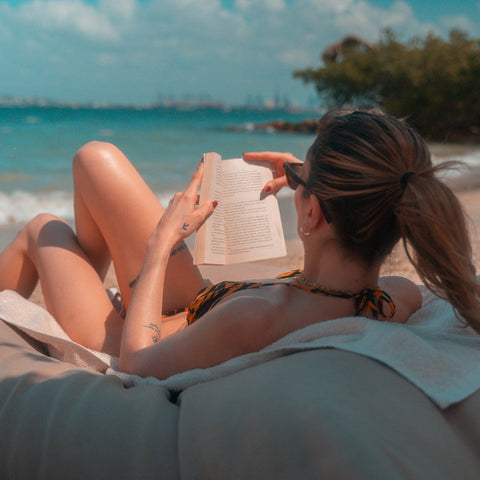 Woman reading a book on a beach with ocean view Fenix Beach