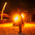 Person performing with fire on a beach at night