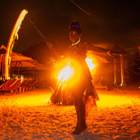 Person performing with fire on a beach at night